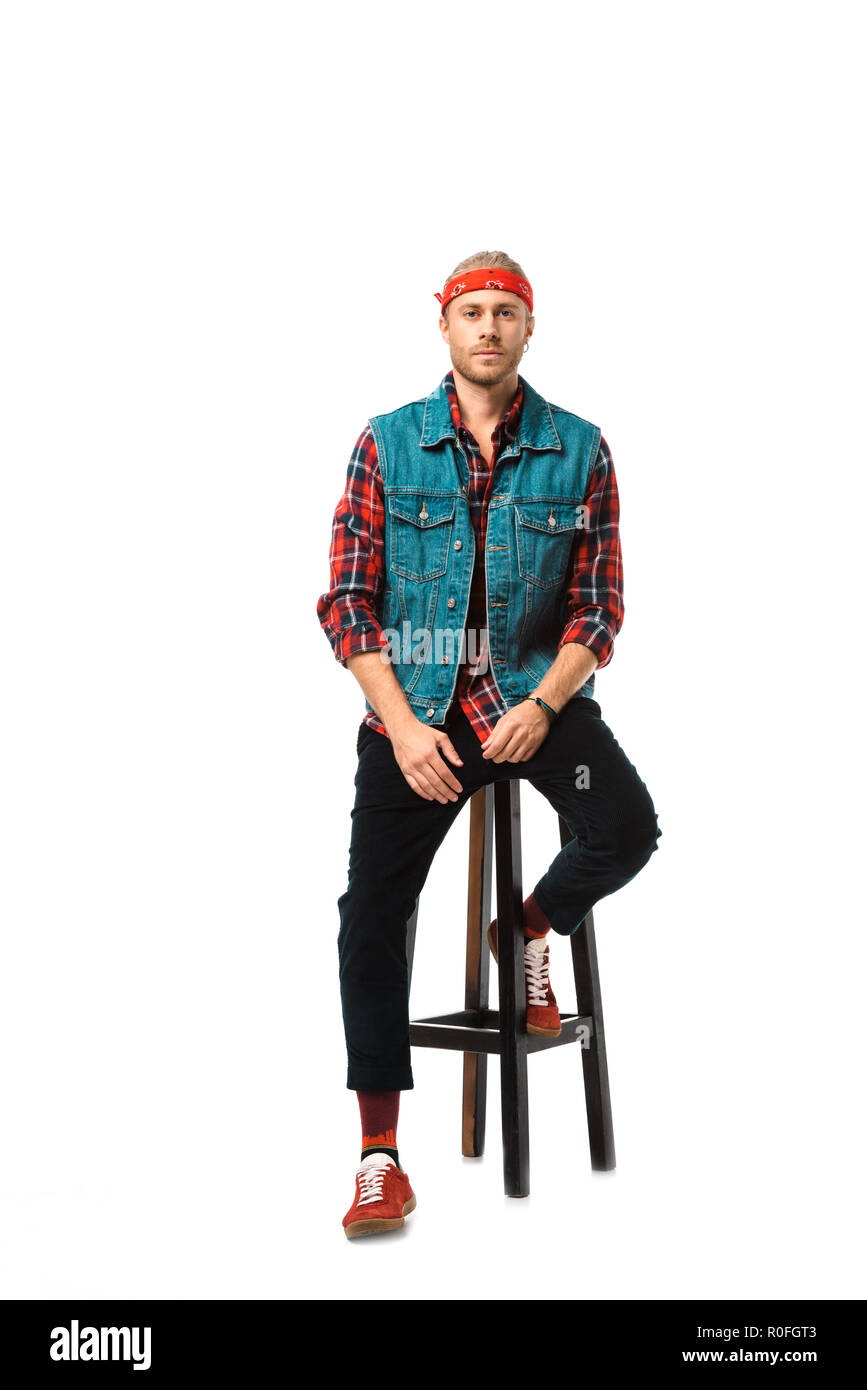 Moda Hombre hipster en jeans chaleco y camisa a cuadros rojo sentado en una  silla aislado en blanco Fotografía de stock - Alamy