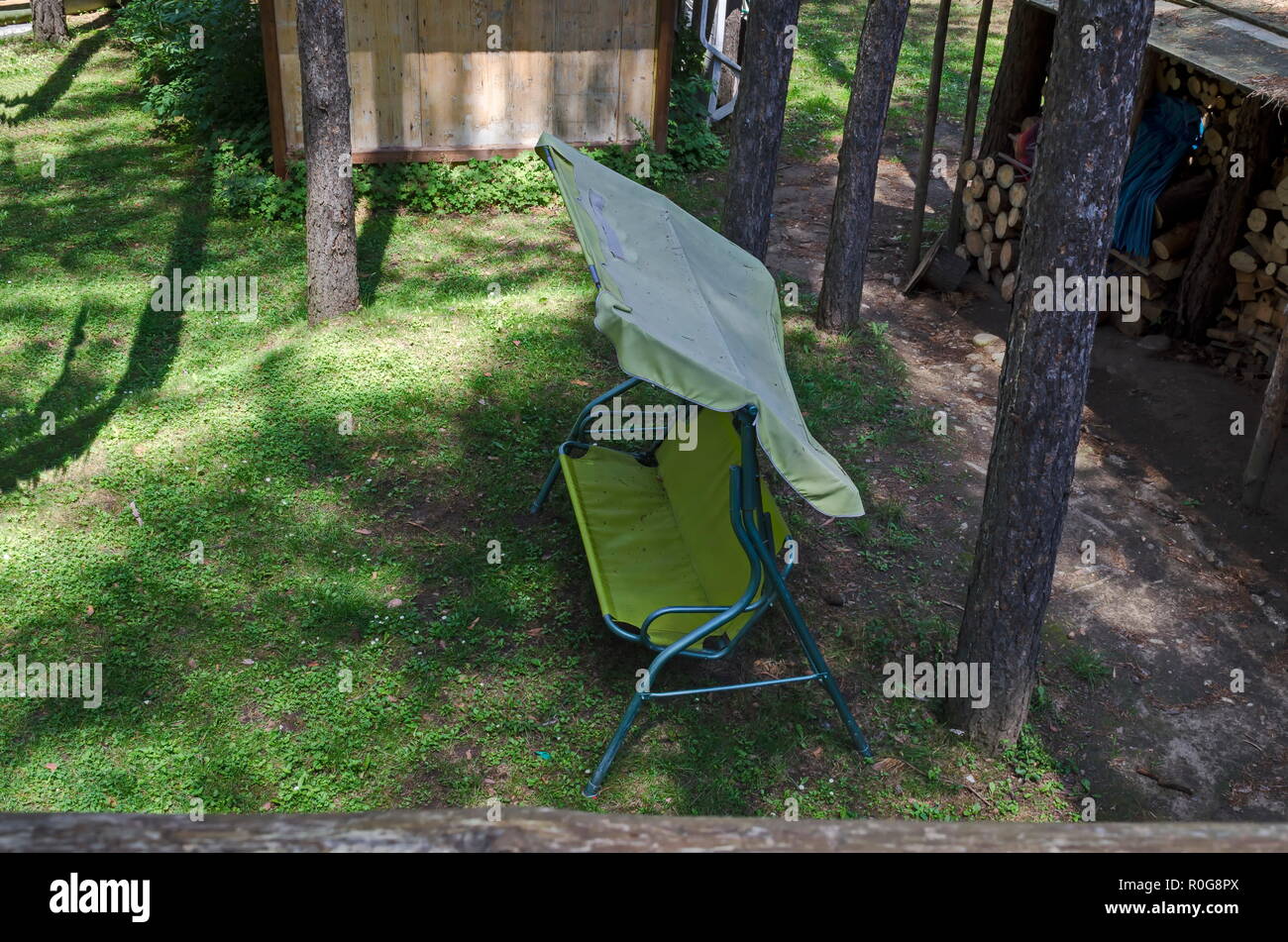 Verano vivac público infantil con columpio jardín y casa de madera en los bosques de coníferas, cerca de la aldea de Pasarel, Bulgaria Foto de stock