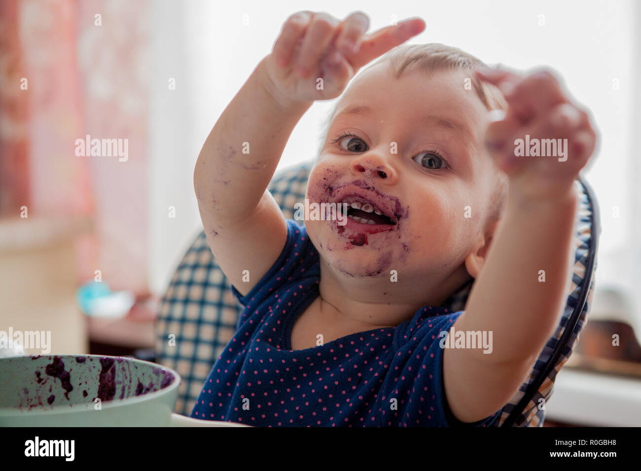 Niño pequeño muchacho con cara sucia comiendo arándanos