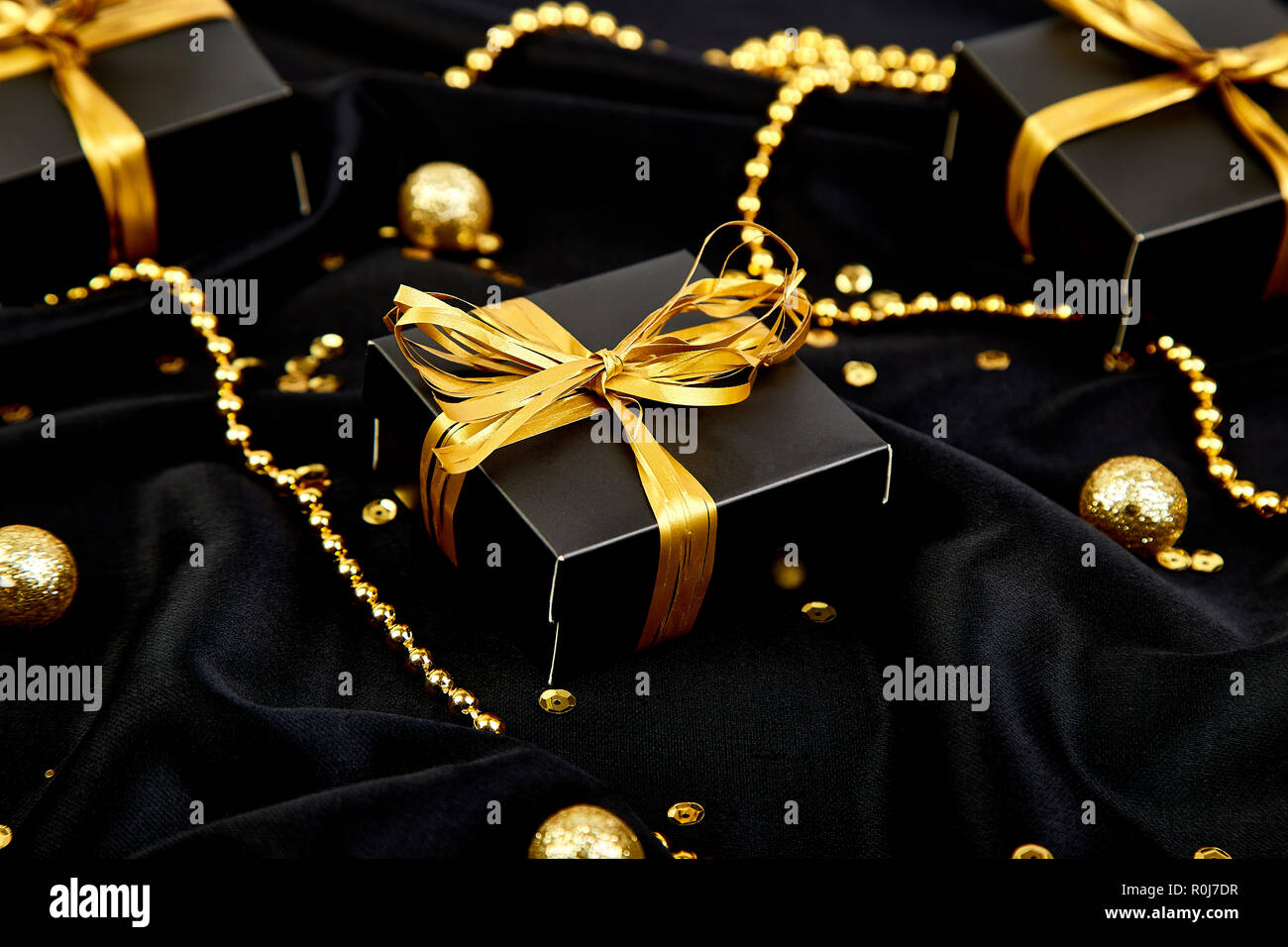Negro con cajas de regalo de lujo gold ribbon en zapatos de fondo. Navidad,  fiesta de cumpleaños regalos. Sentar planas. Copie el espacio. Vista desde  arriba Fotografía de stock - Alamy