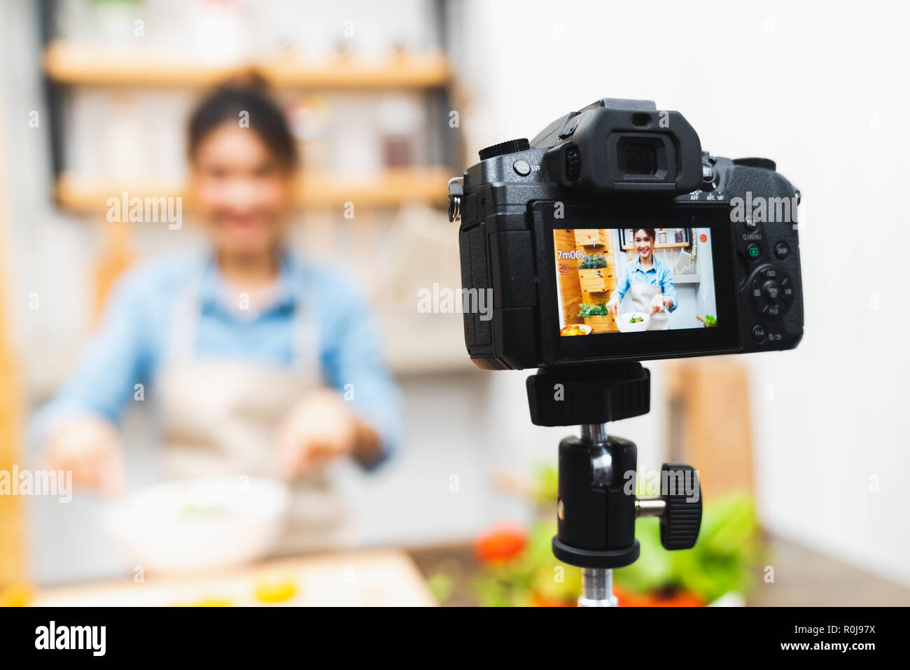 Jóvenes asiáticos lindo blogger chica grabar video tutorias de ensalada lección de cocina cocina en casa. Blogs de alimentos o vlogging, medios sociales hobby Foto de stock