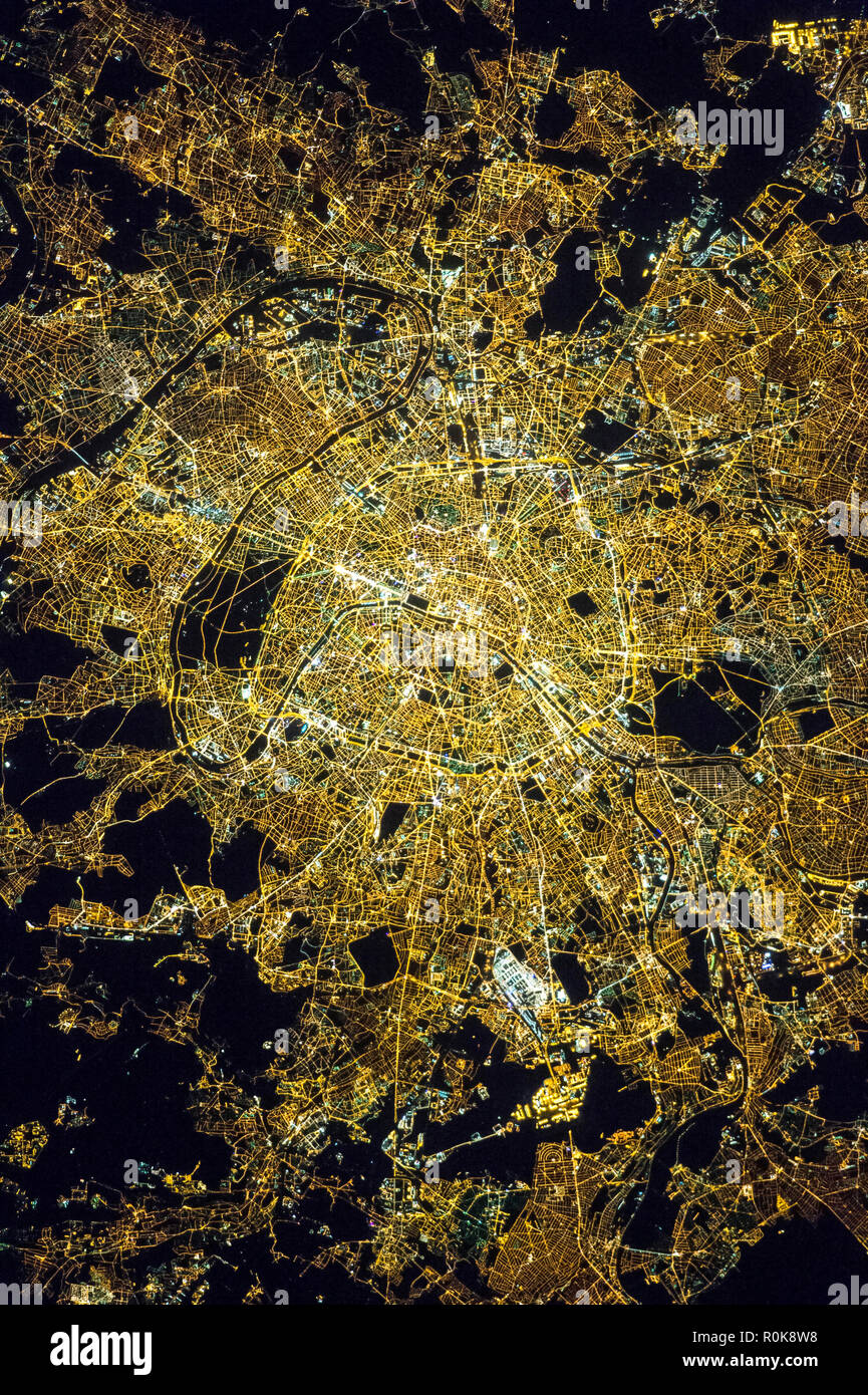 Vista desde el espacio de París, Francia, mostrando el patrón de cuadrícula de la calle y las luces de la ciudad por la noche. Foto de stock
