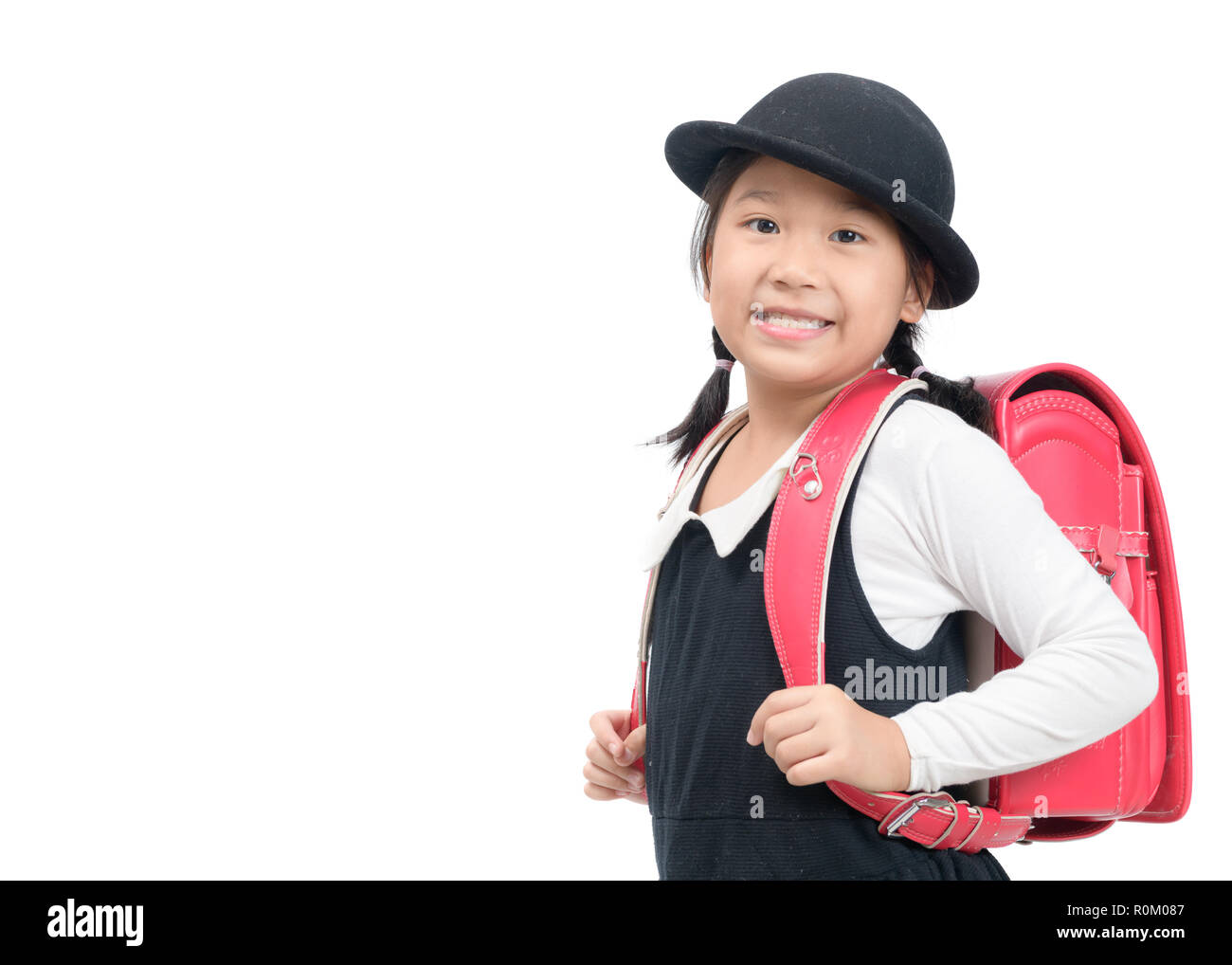 Niña adolescente positiva usa sombrero con orejeras con mochila escolar y  juguete sobre fondo amarillo de regreso a la escuela