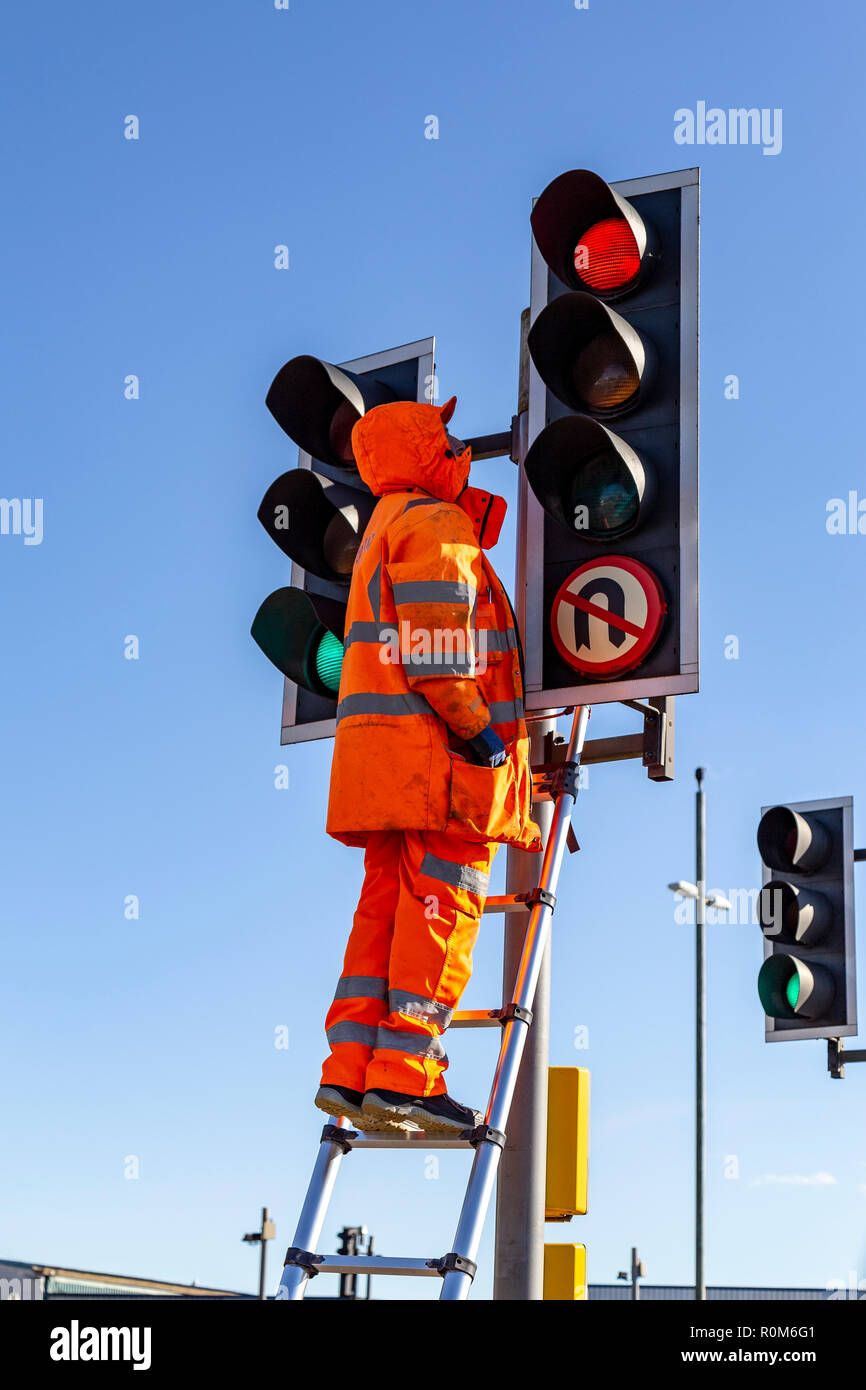 Hombre reparando semáforos,operadas automáticamente las luces de colores,controlando el tráfico, cruces de carreteras, pasos de peatones, semáforos, tráfico Foto de stock
