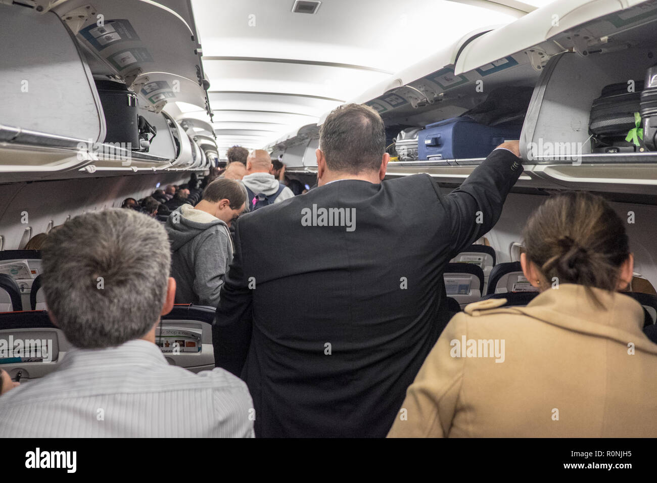 Los pasajeros,esperando,a,desembarcar,y,tomar,su equipaje,,de,sobrecarga,compartimentos,  en,Manchester,aeropuerto,después,llegando,a,a,Brussels Airlines, vuelo  Fotografía de stock - Alamy