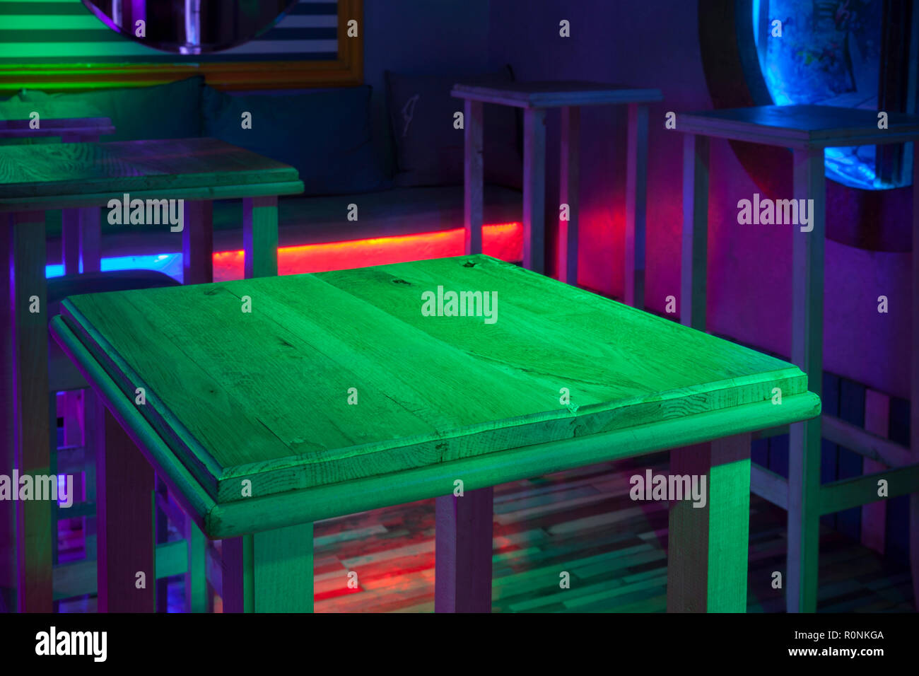 Mesa de madera en una habitación oscura con luces de discoteca Fotografía  de stock - Alamy