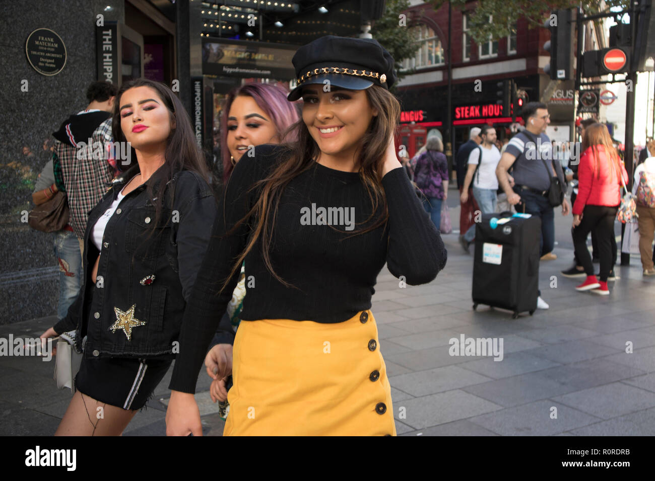 Londres, Inglaterra - 15 de septiembre de 2018, una multitud de personas están caminando a lo largo de Street. Amigos de moda en faldas cortas posando Fotografía de stock -