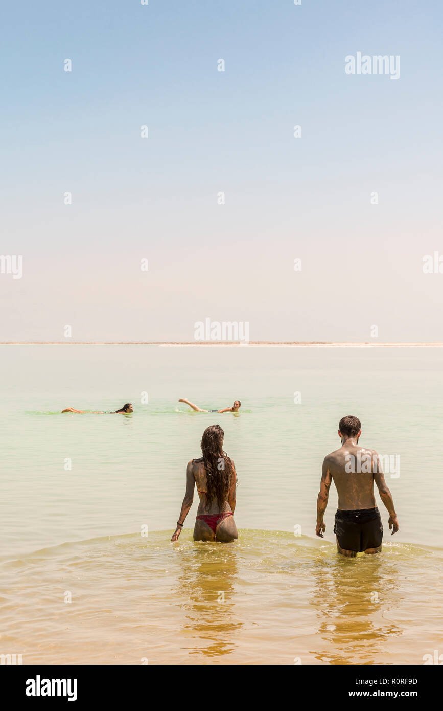 Dos personas bañarse en el Mar Muerto, untado con barro, Ein Bokek, Playa del Mar Muerto, Playa Kalia, Israel Foto de stock