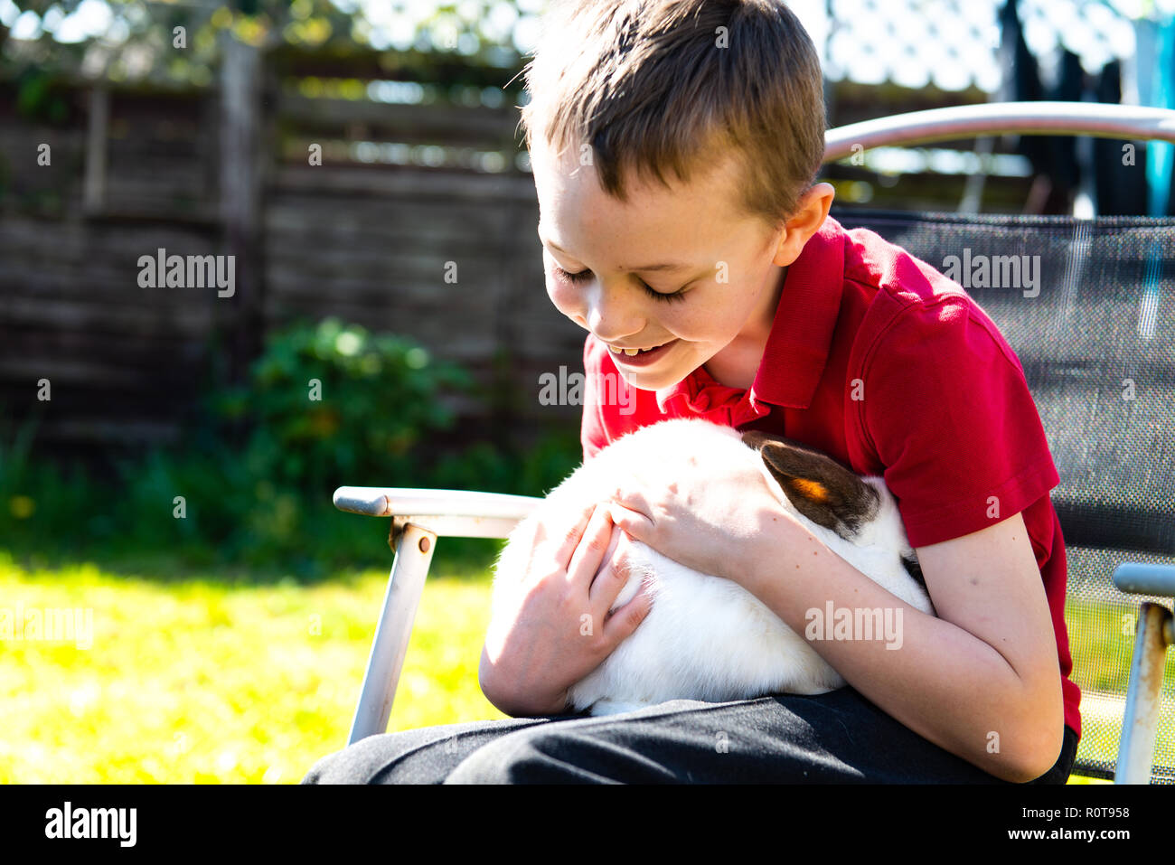 Un guapo feliz sonriente niño con autismo, síndrome de Asperger y síndrome  TDAH mimar a su mascota favorita de conejo en el jardín de su casa  Fotografía de stock - Alamy