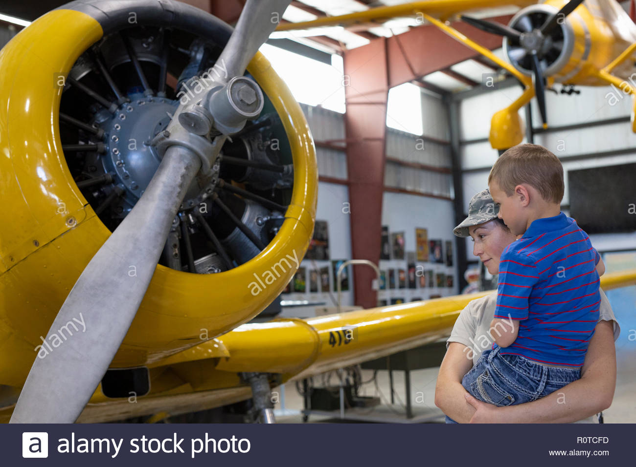 Piloto del ejército femenino mostrando madre hijo avión en avión militar museo Foto de stock