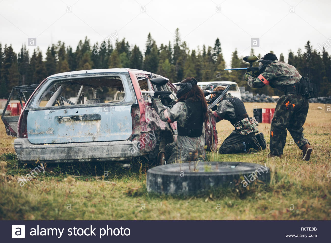 Equipo paintball detrás oxidado viejo coche Foto de stock