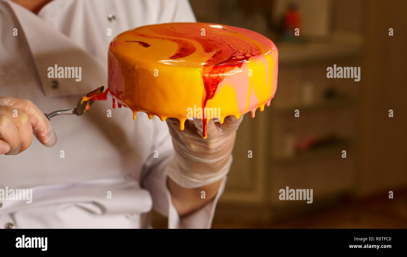 Tarta de mousse de yogur. La niña crea un dibujo de espuma sobre el