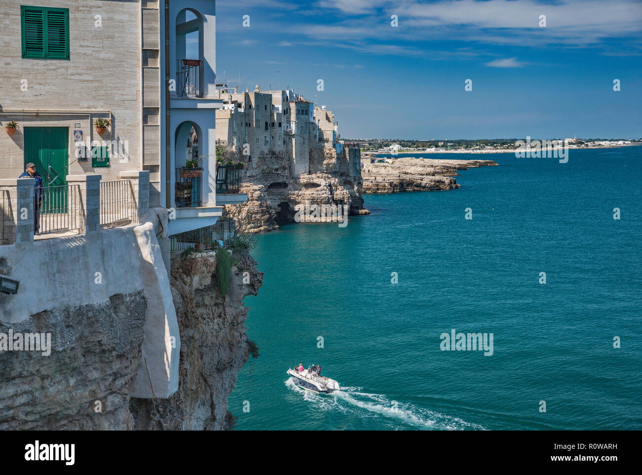 Casas encaramadas en las rocas encima del mar Adriático, desde el punto de vista de Largo Ardito, en Polignano a Mare, Puglia, Italia Foto de stock
