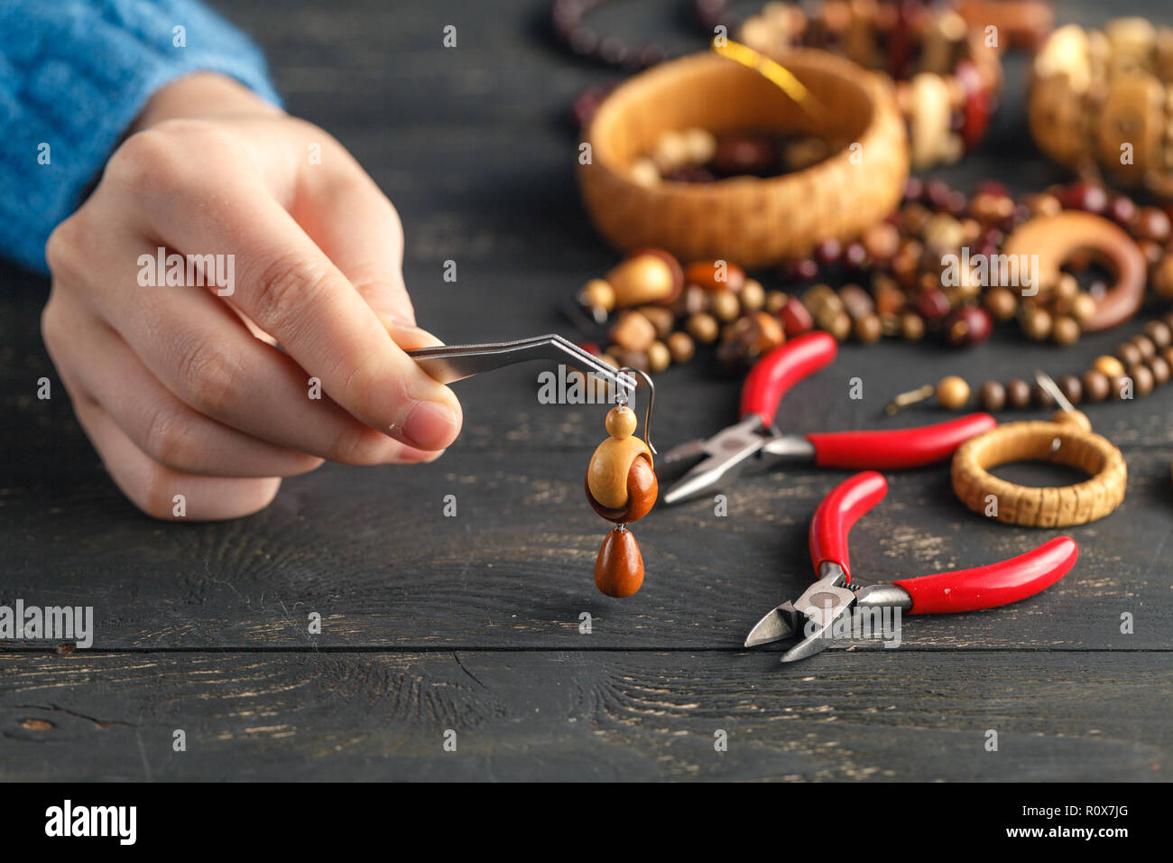 Persona haciendo joyas utilizando cadenas y abalorios y otros materiales con Herramientas artesanas de stock - Alamy