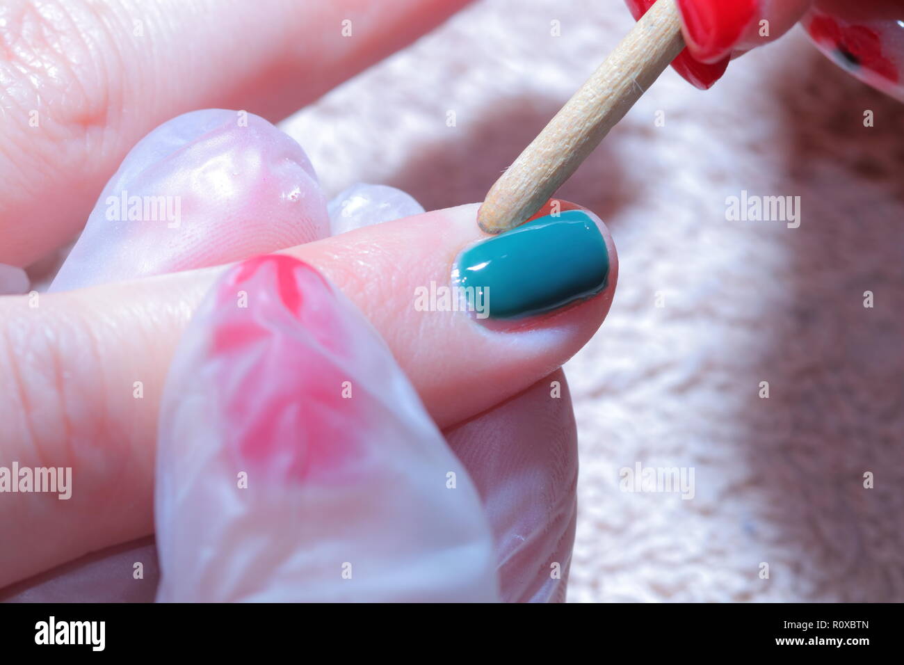 Técnico de uñas aplicando esmalte de uñas de color verde. Foto de stock