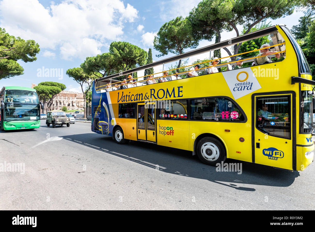 Roma, Italia - 4 de septiembre de 2018: el Vaticano y Roma amarillo tour double decker hop on hop off bus con el coliseo anfiteatro en el fondo, la gente en b Foto de stock