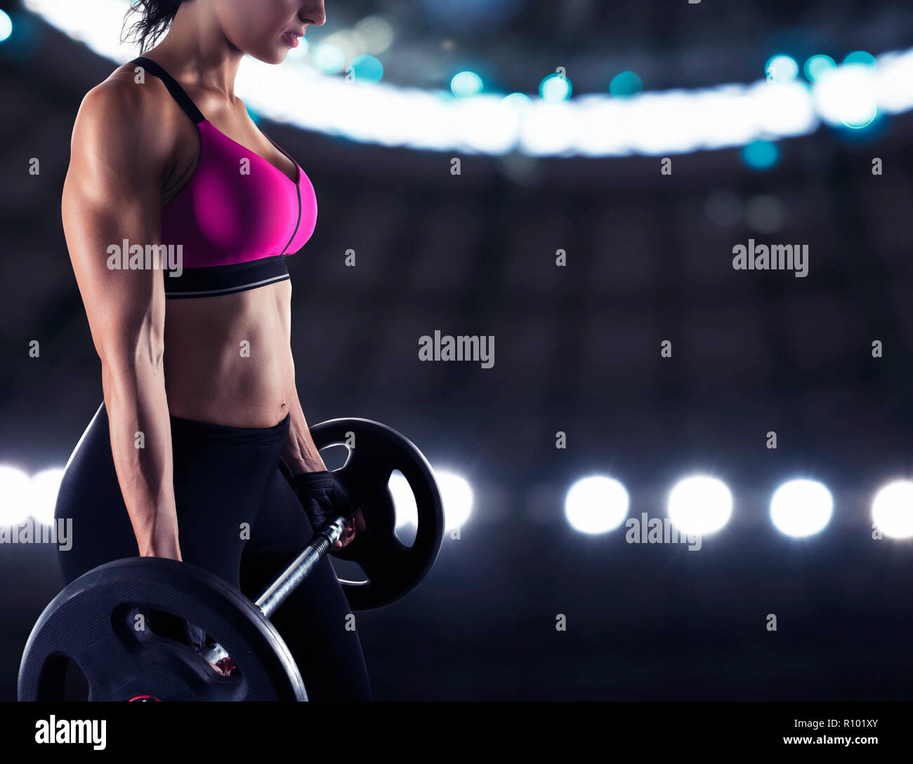 Mujer atlética bíceps entrenamiento en el gimnasio Foto de stock