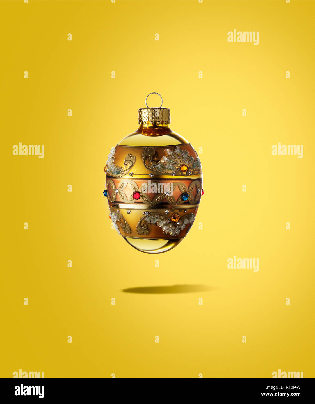 Cerca de adornos de Navidad regal flotando con sombra, fondo amarillo Foto de stock