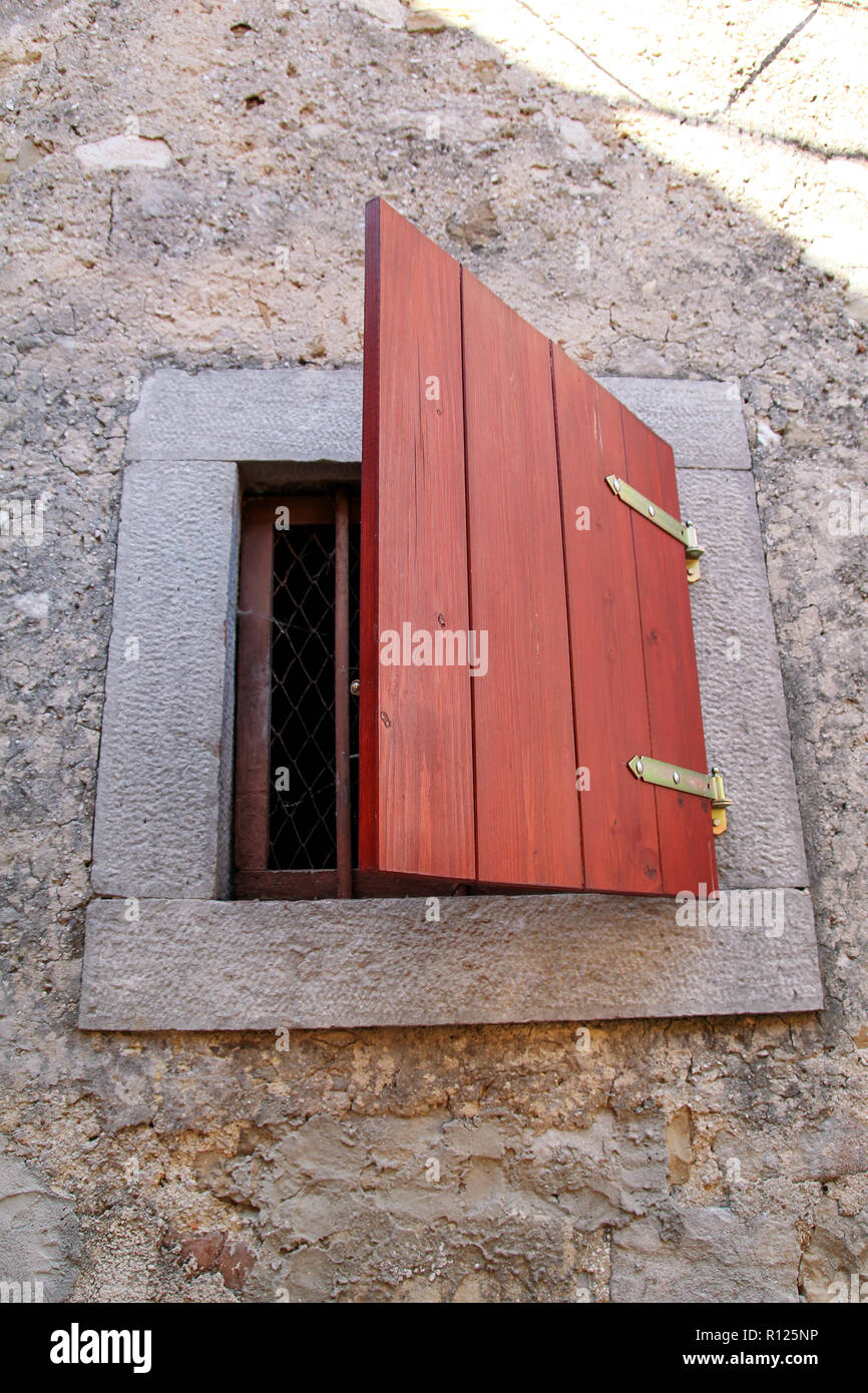 Detalle arquitectónico: pequeña ventana rústica en una casa tradicional  mediterráneo. Formato Vertical, luz natural / antiguas pequeñas ventanas  con persianas de madera Fotografía de stock - Alamy