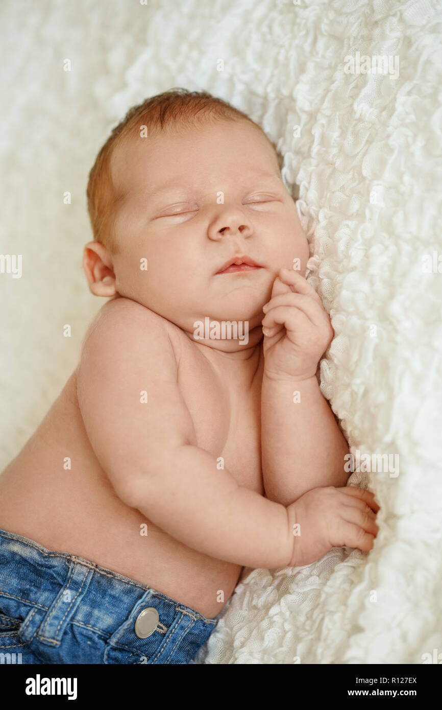 La moda en jeans de bebé recién nacido duerme en la cama. Moda para niños  Fotografía de stock - Alamy