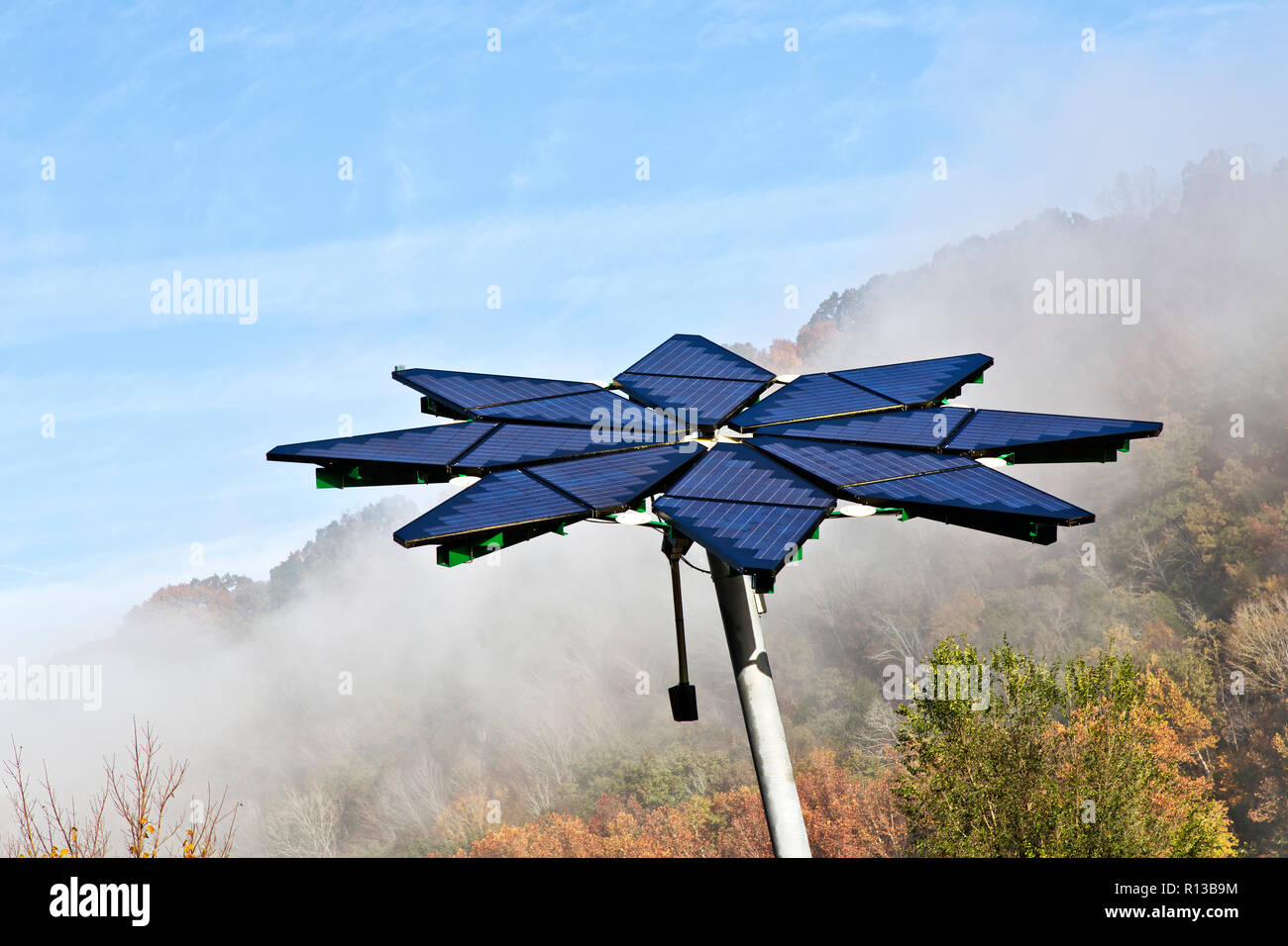 Matriz Solar identificado como "Solar Fotovoltaica Flair", facilita la estación de recarga de vehículos eléctricos, disipando la niebla matutina. Foto de stock