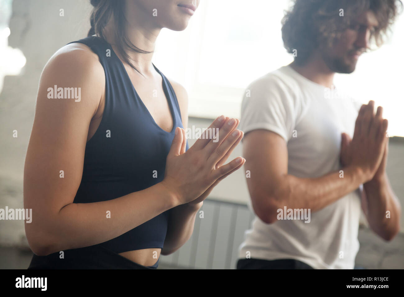 Hombre y mujer joven namaste gesto lección de yoga Foto de stock