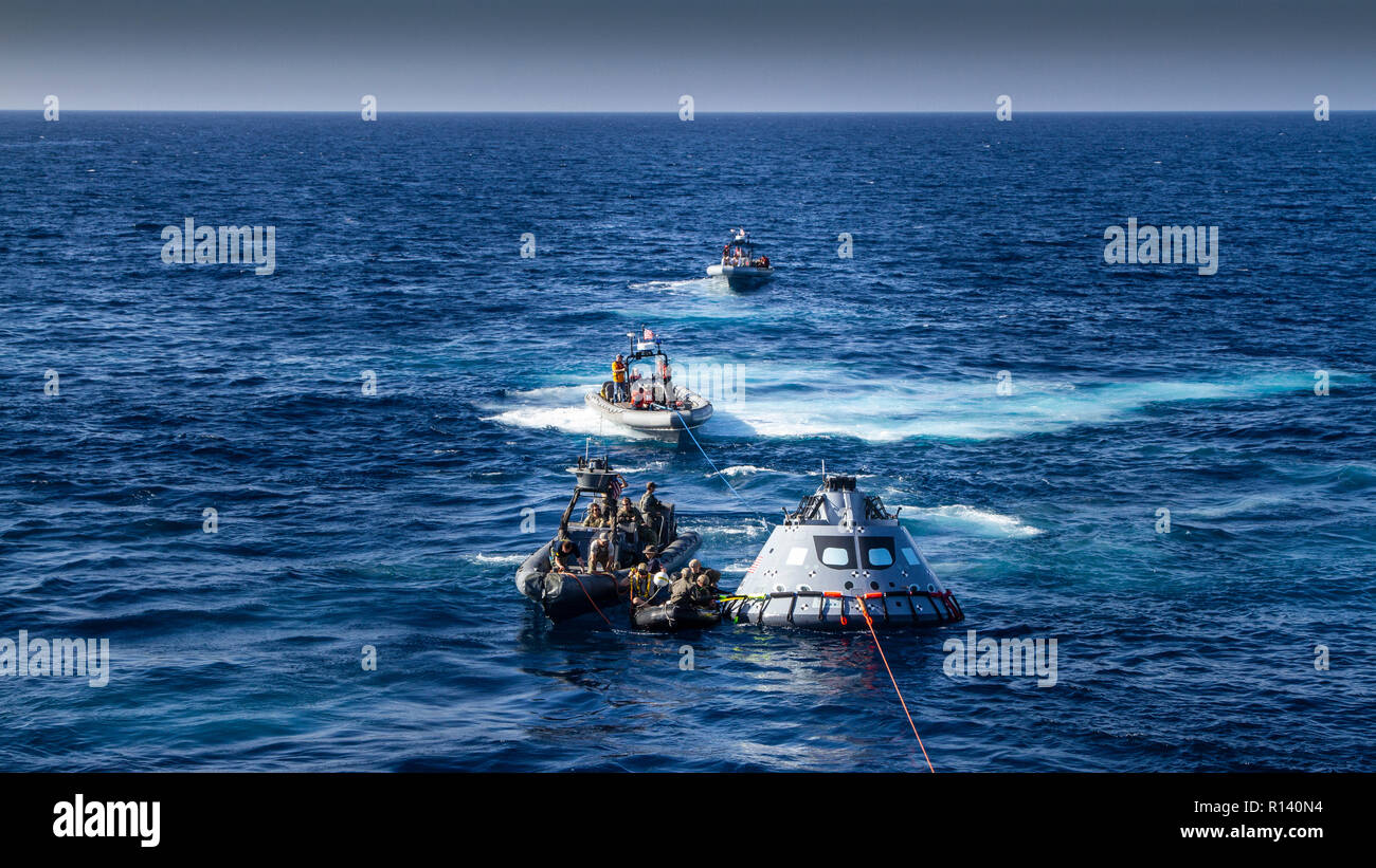 Los buzos de la Marina de EE.UU. Realice un cable a la versión de maquetas de la NASA Orion cápsula espacial de próxima generación durante un test de recuperación el 31 de octubre de 2018, en el Océano Pacífico. La NASA y la Marina de los EE.UU. no ha realizado la recuperación del océano abierto de una cápsula espacial tripulada desde el proyecto Apolo en la década de los 60's y son procedimientos de pruebas y el hardware que se utilizará para recuperar la nave espacial Orion después que salpica en el Océano Pacífico después de futuras misiones de exploración del espacio profundo. Foto de stock