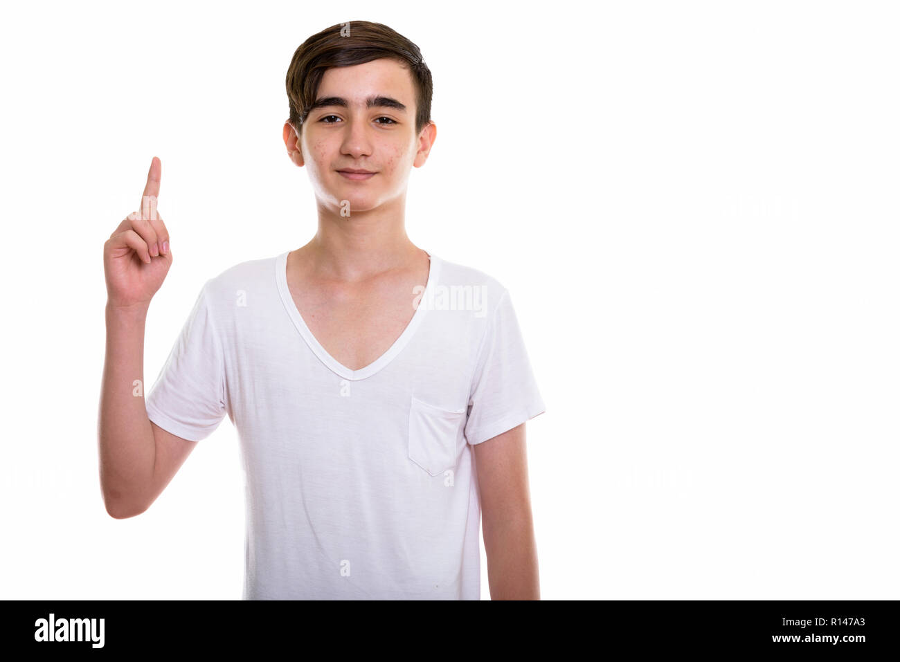 Foto de estudio de joven apuesto adolescente apuntando finge persa Foto de stock