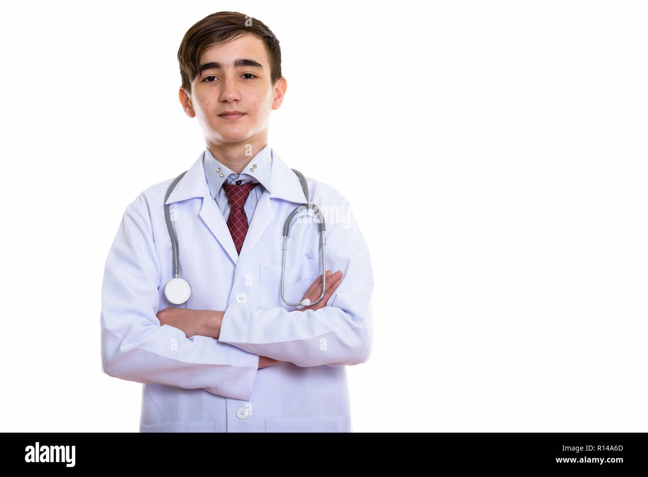 Foto de estudio de joven apuesto doctor adolescente persa con brazos c Foto de stock
