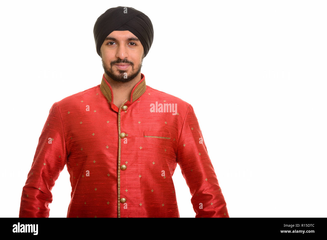 Joven apuesto Sikh indio vistiendo ropas tradicionales Foto de stock