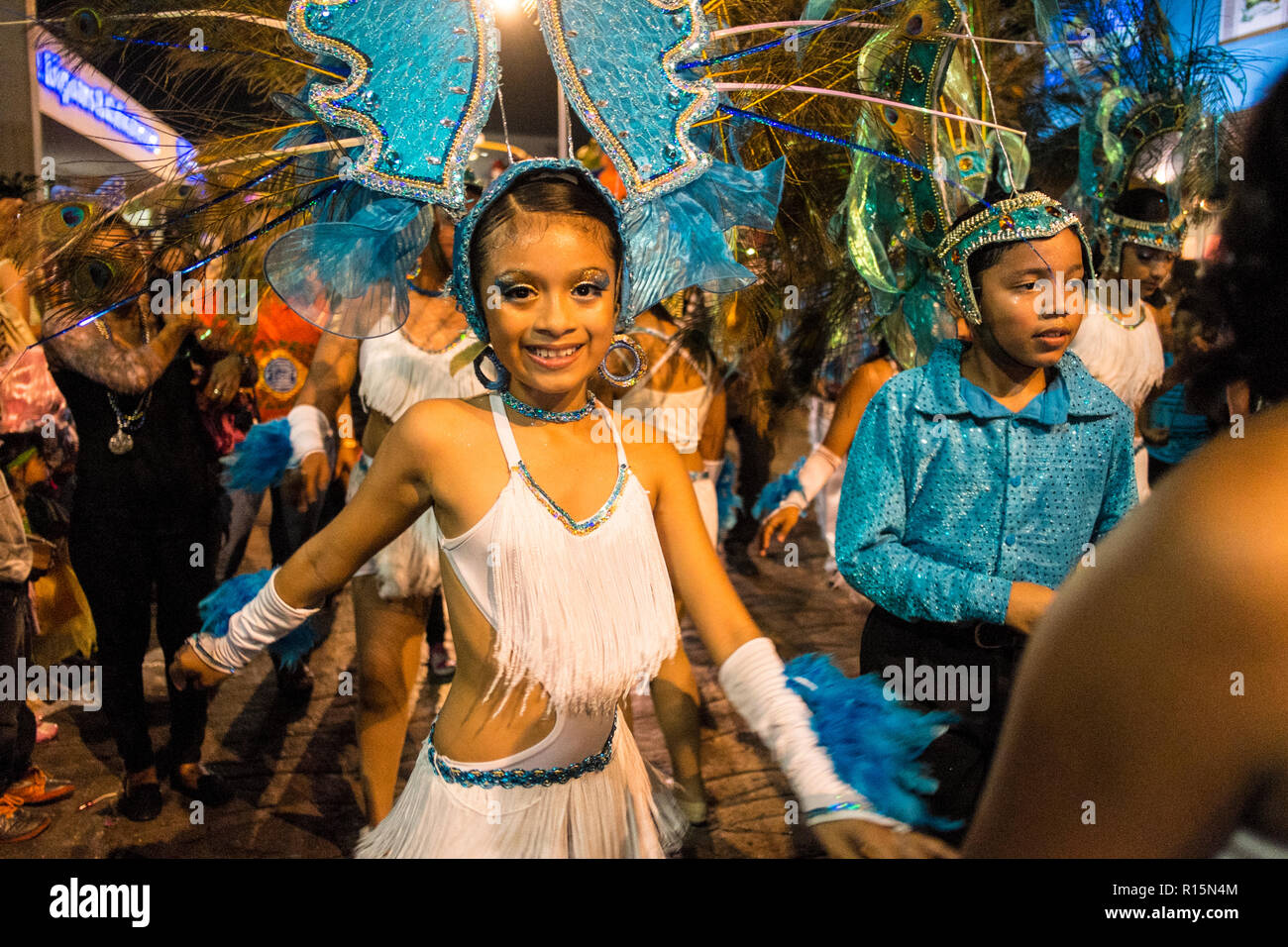 Hermosa mujer brasileña vistiendo coloridos trajes de carnaval y sonriendo  durante el desfile de carnaval en la ciudad.