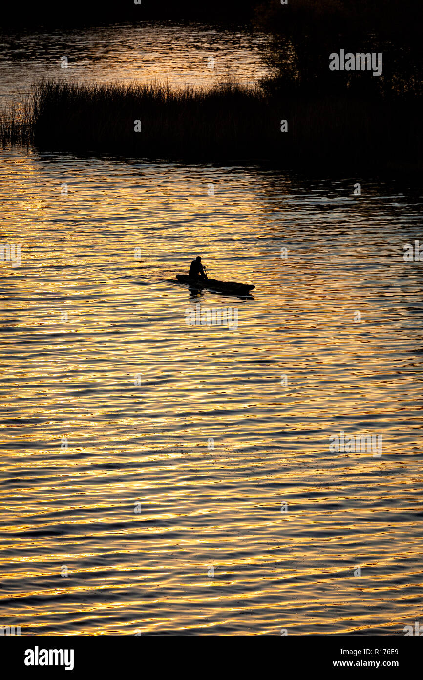 Un pescador de filas a través del lago Zirahuen al amanecer, Michoacán, México. Foto de stock