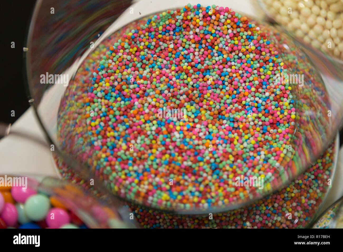 mano antecedentes Instalaciones Confeti de colores dulces dentro del recipiente de vidrio transparente  Fotografía de stock - Alamy