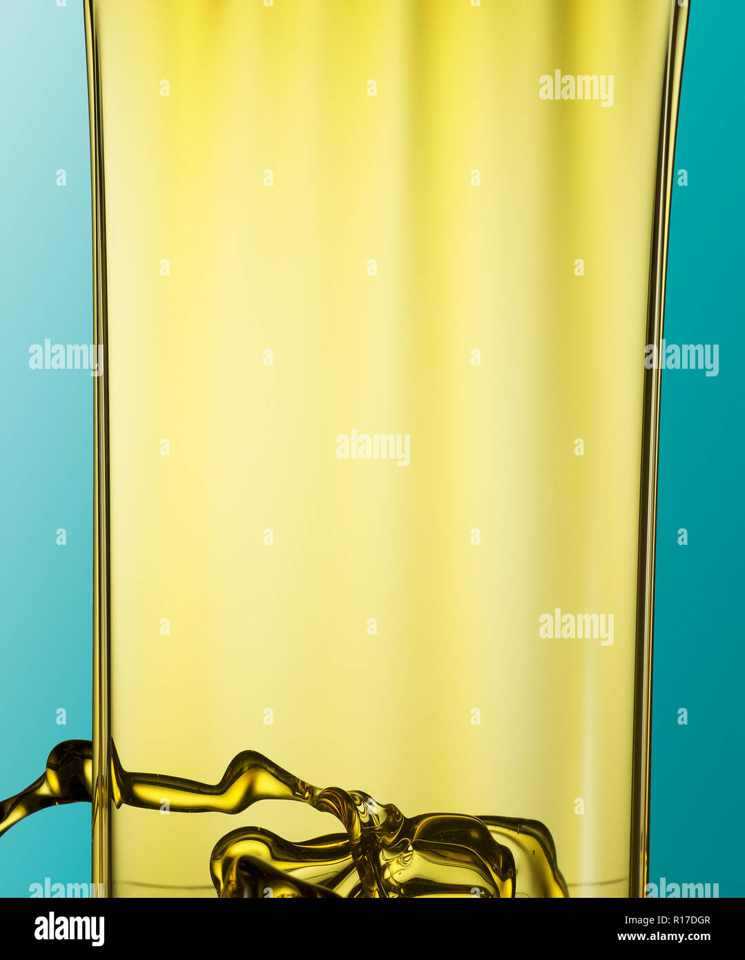 Franja de color dorado aceite fluyendo hacia abajo contra el fondo azul. Foto de stock