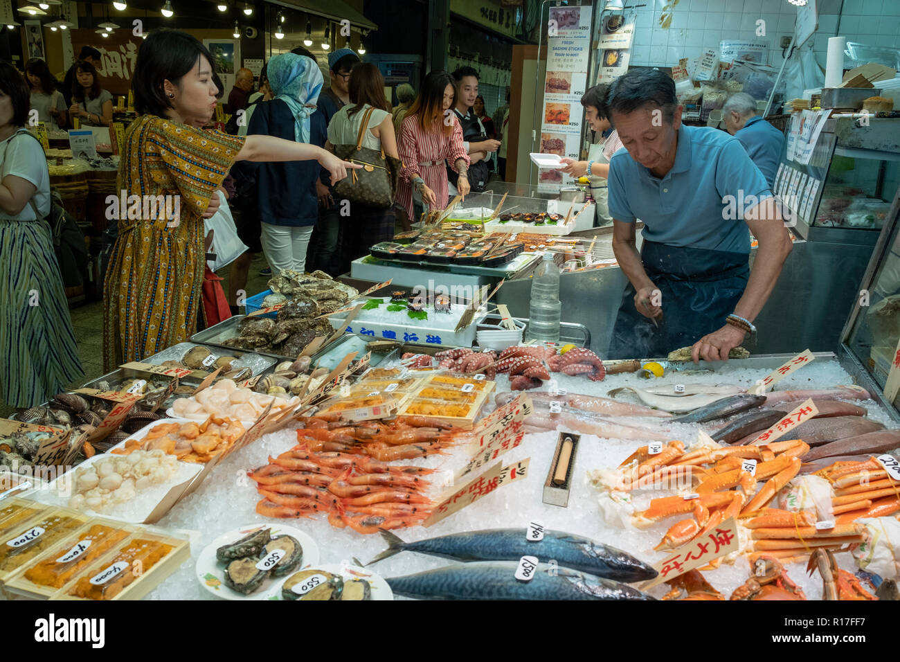 Los clientes en el mercado de alimentos Nishiki Dera, en Kyoto, Kansai, Japón Foto de stock