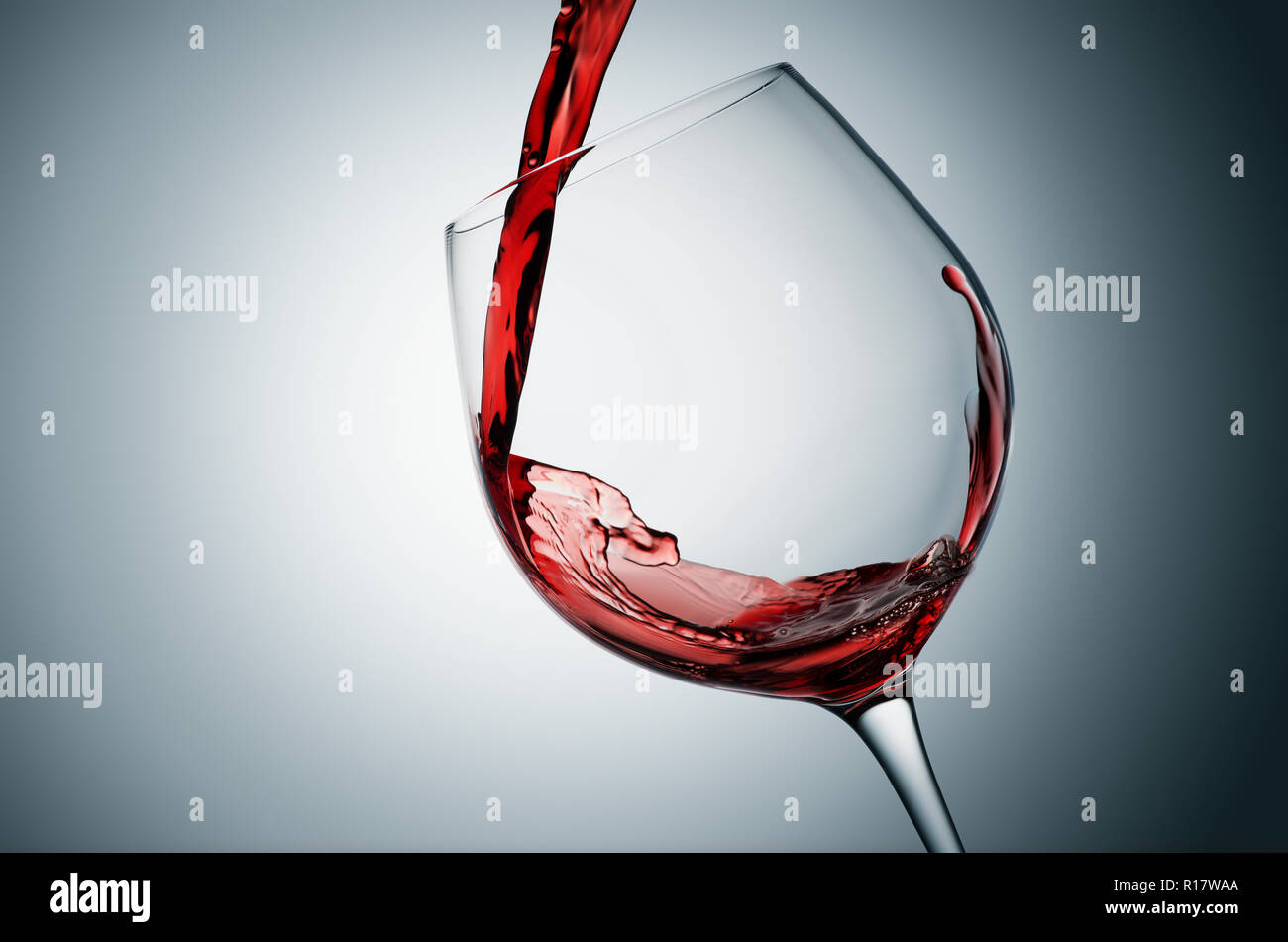 Verter el vino tinto en vidrio inclinado, fondo gris Foto de stock