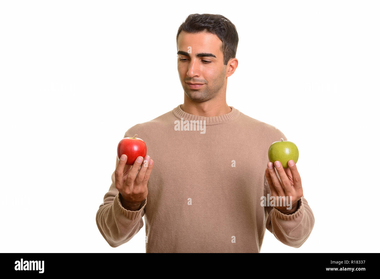 Apuesto hombre persa mantiene saludable manzana verde y rojo Foto de stock
