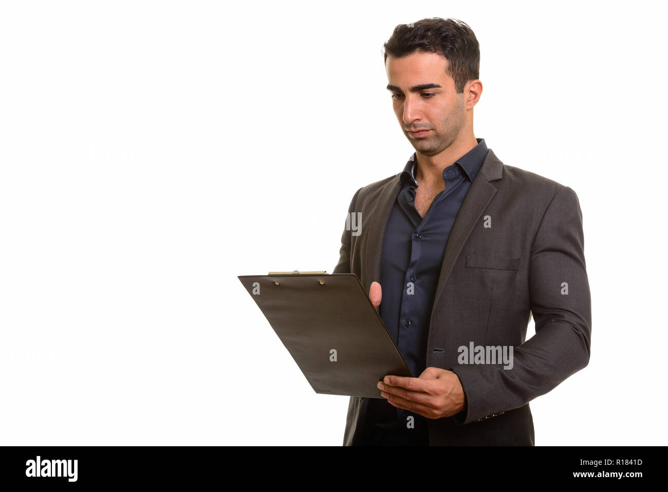 Retrato de joven apuesto empresario persa con portapapeles Foto de stock