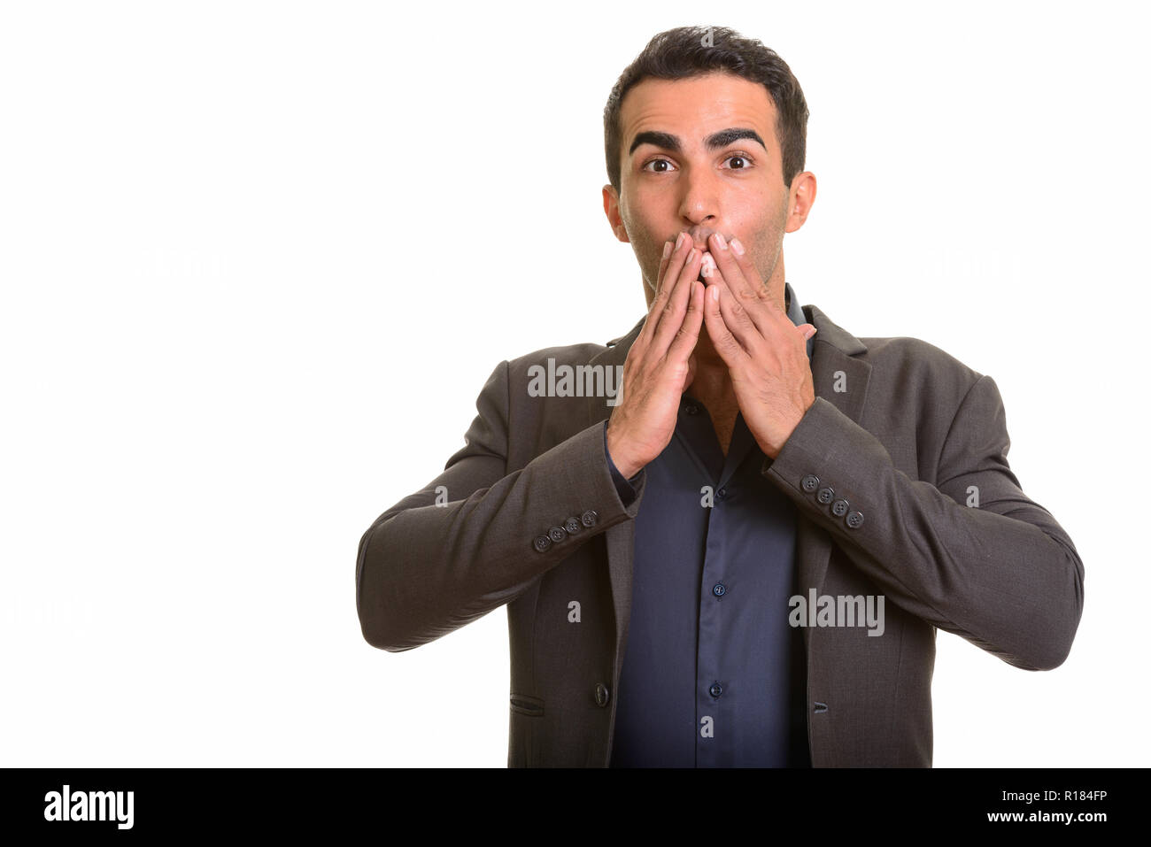 Retrato de joven apuesto empresario persa mirando sorprendido Foto de stock