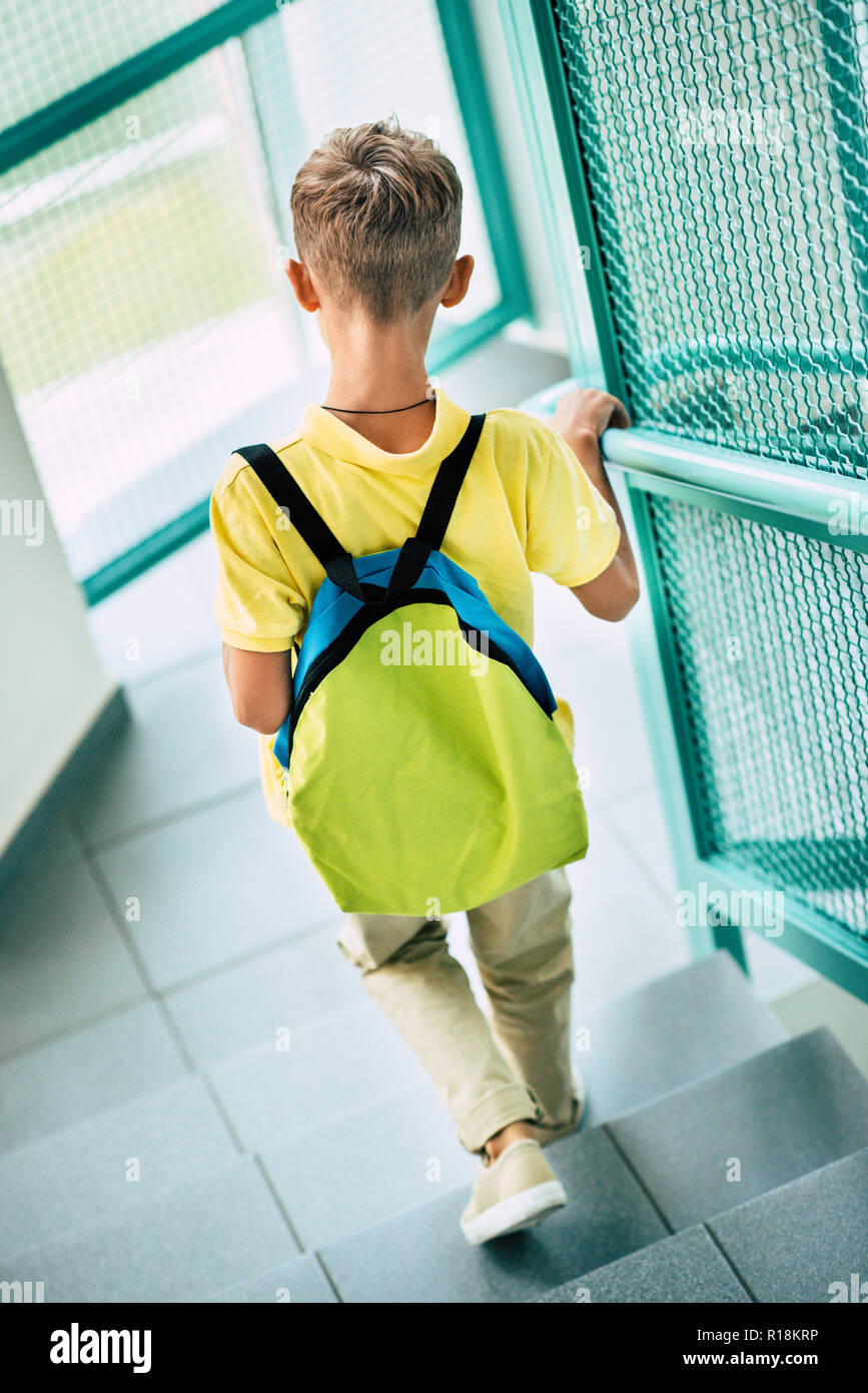 Vista trasera de colegial con mochila ir abajo en el corredor de la escuela  Fotografía de stock - Alamy