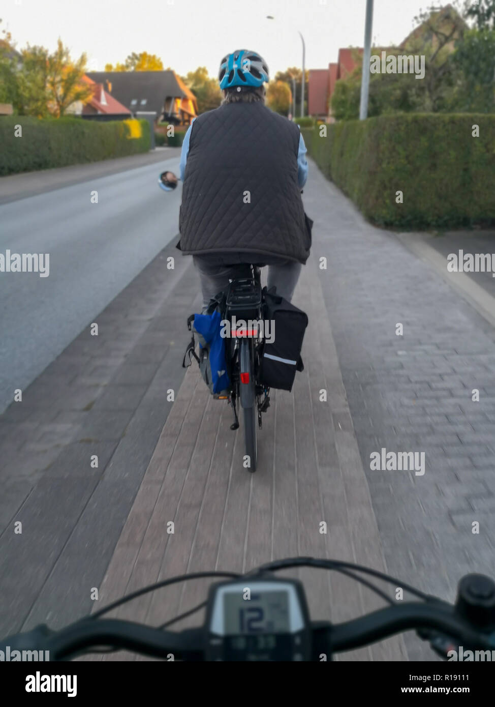 Un ciclista con casco impulsa hacia delante. Perspectiva Personal durante un paseo en bicicleta en el otoño. Foto de stock
