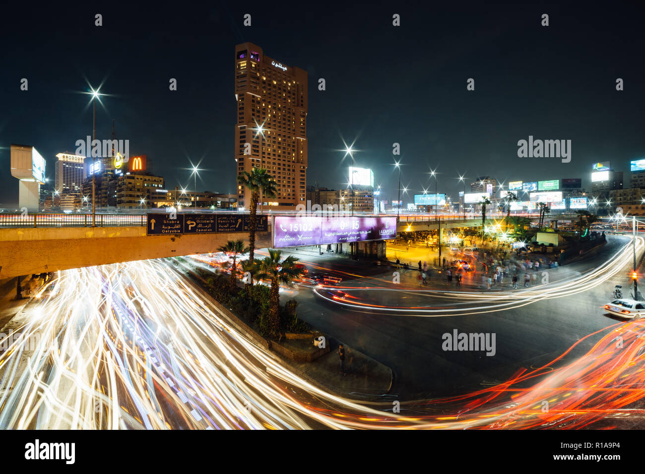 El Cairo, Egipto - Noviembre 8, 2018: El concurrido Abdel Munim Riad square y la estación de autobús en el centro de Cairo por la noche, la larga exposición con semáforo senderos. Foto de stock