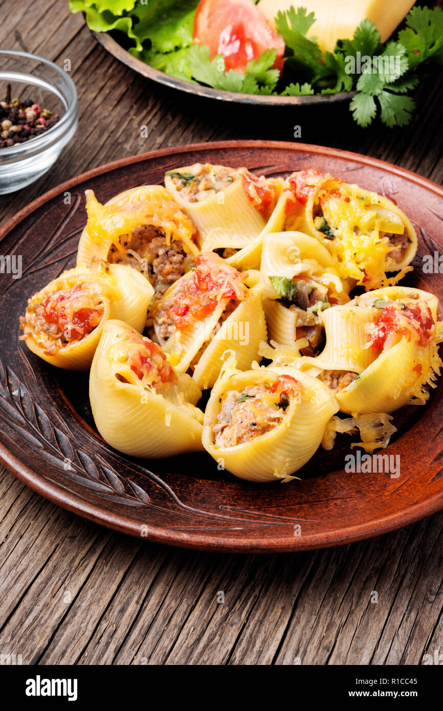 El italiano pastas alimenticias rellenas con carne a la plancha de  madera.rellenos de queso ricotta conchas Fotografía de stock - Alamy