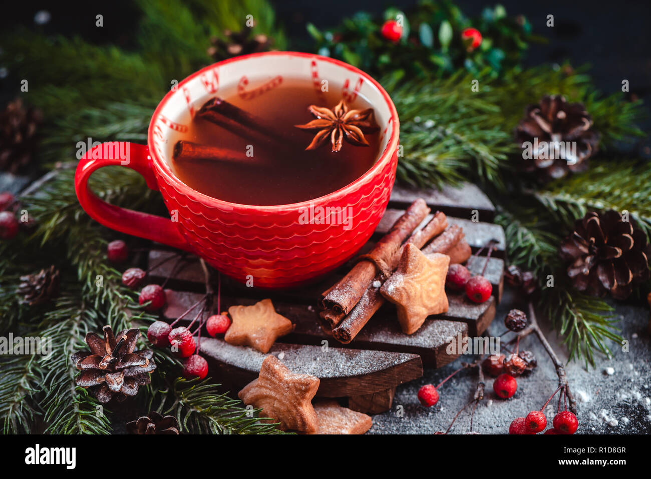 Navidad con canela, té caliente y galletas en forma de estrella. Gran taza de café casero con cacao. Hornear de invierno fotografía sobre un fondo oscuro Foto de stock