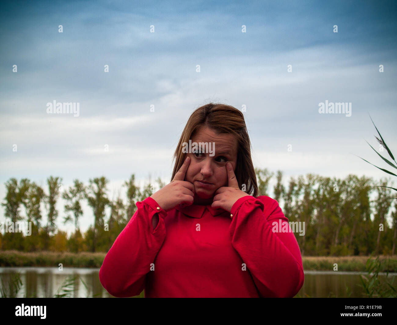 Una joven gestouring cerca del río en otoño Foto de stock