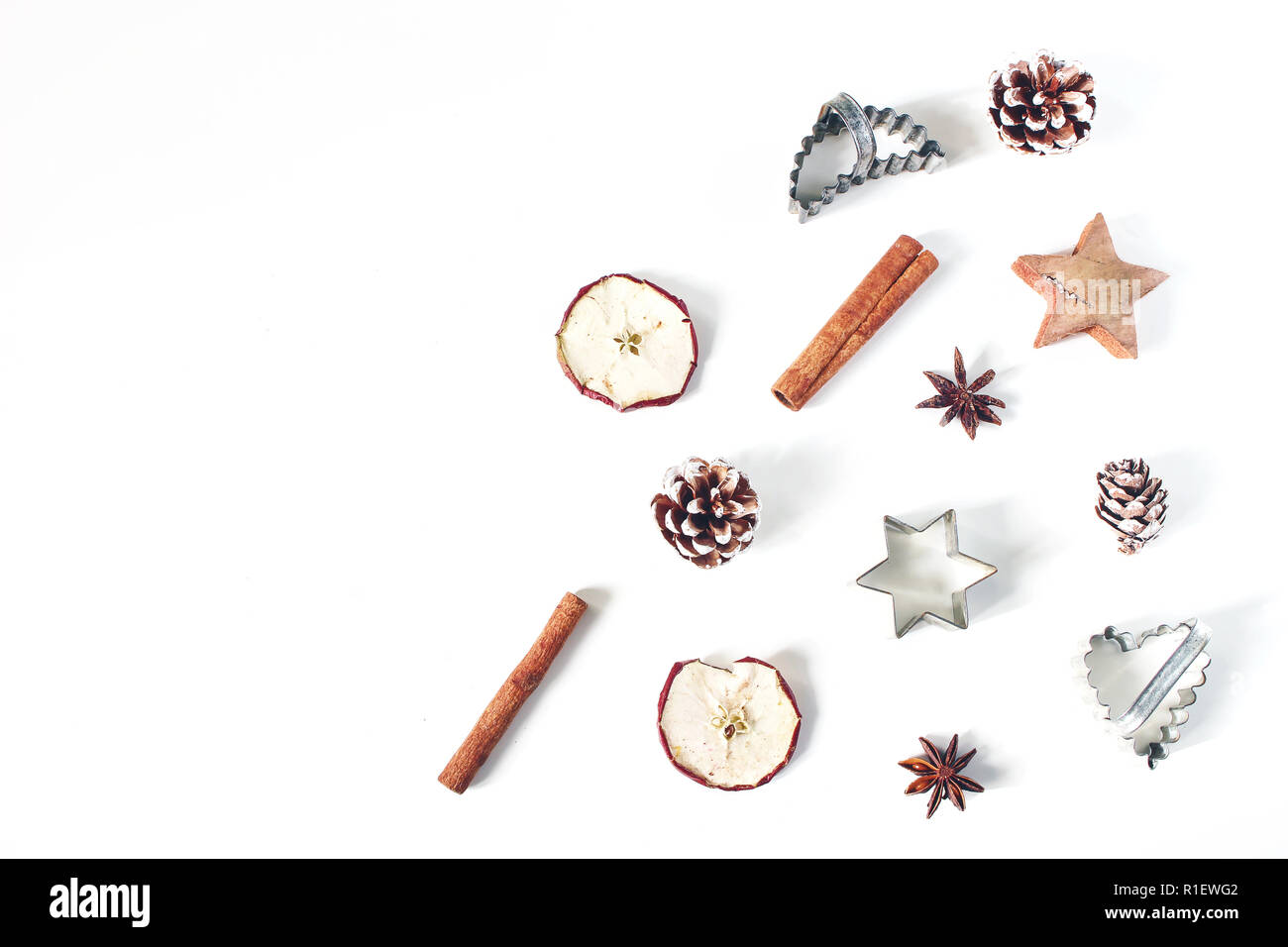 Navidad estilo festivo, el patrón de composición de alimentos. Piñas, manzanas secas, canela, vintage cortadores para galletas y anís estrellas aislado en blanco Foto de stock