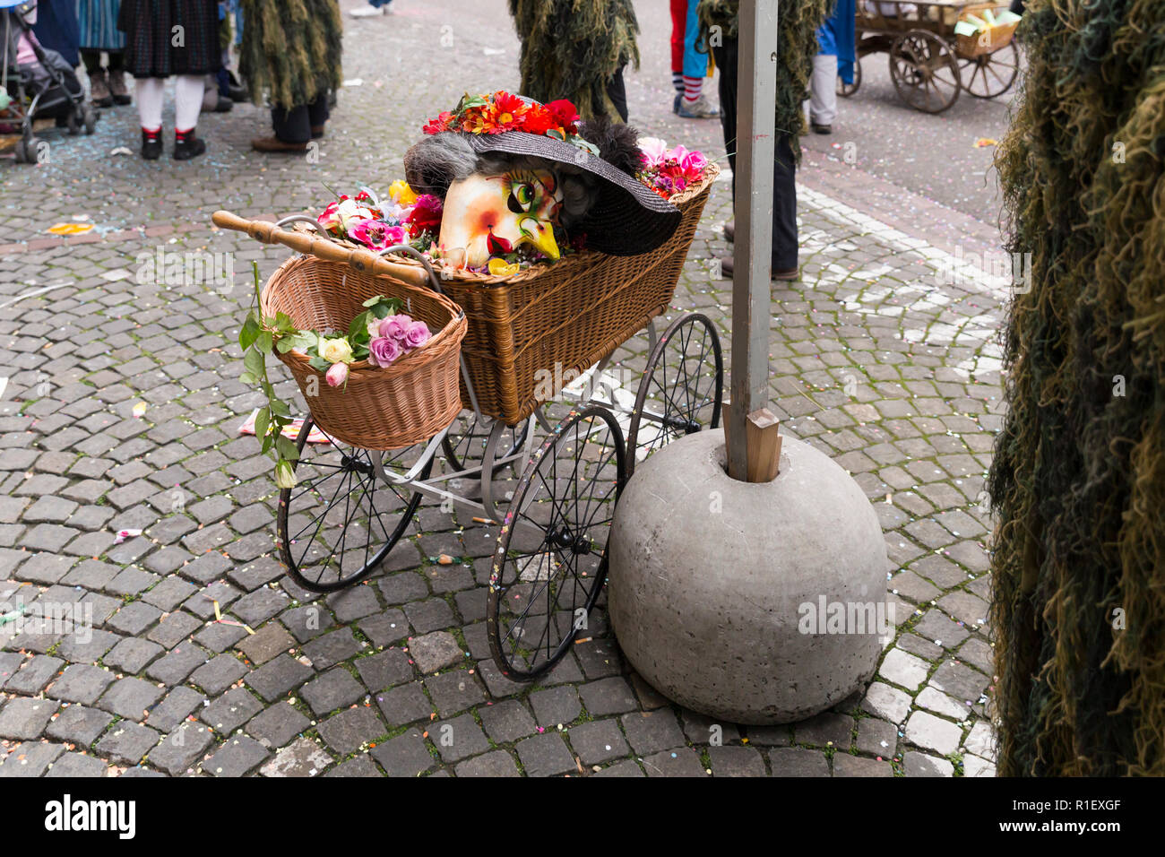 Carnaval de Basilea de 2018. Schneidergasse, Basilea, Suiza - 19 de febrero de 2018. Un viejo estilo baby buggy con una máscara de carnaval perteneciente a un alti dande Foto de stock