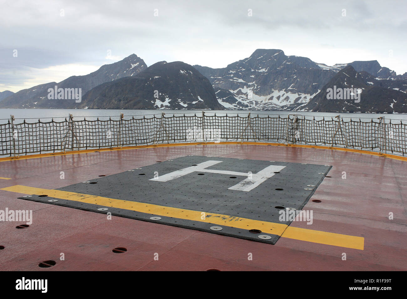 Helideck del CCGS Amundsen en la Bahía de Frobisher, Canadá con picos nevados de las montañas Everett en el fondo Foto de stock