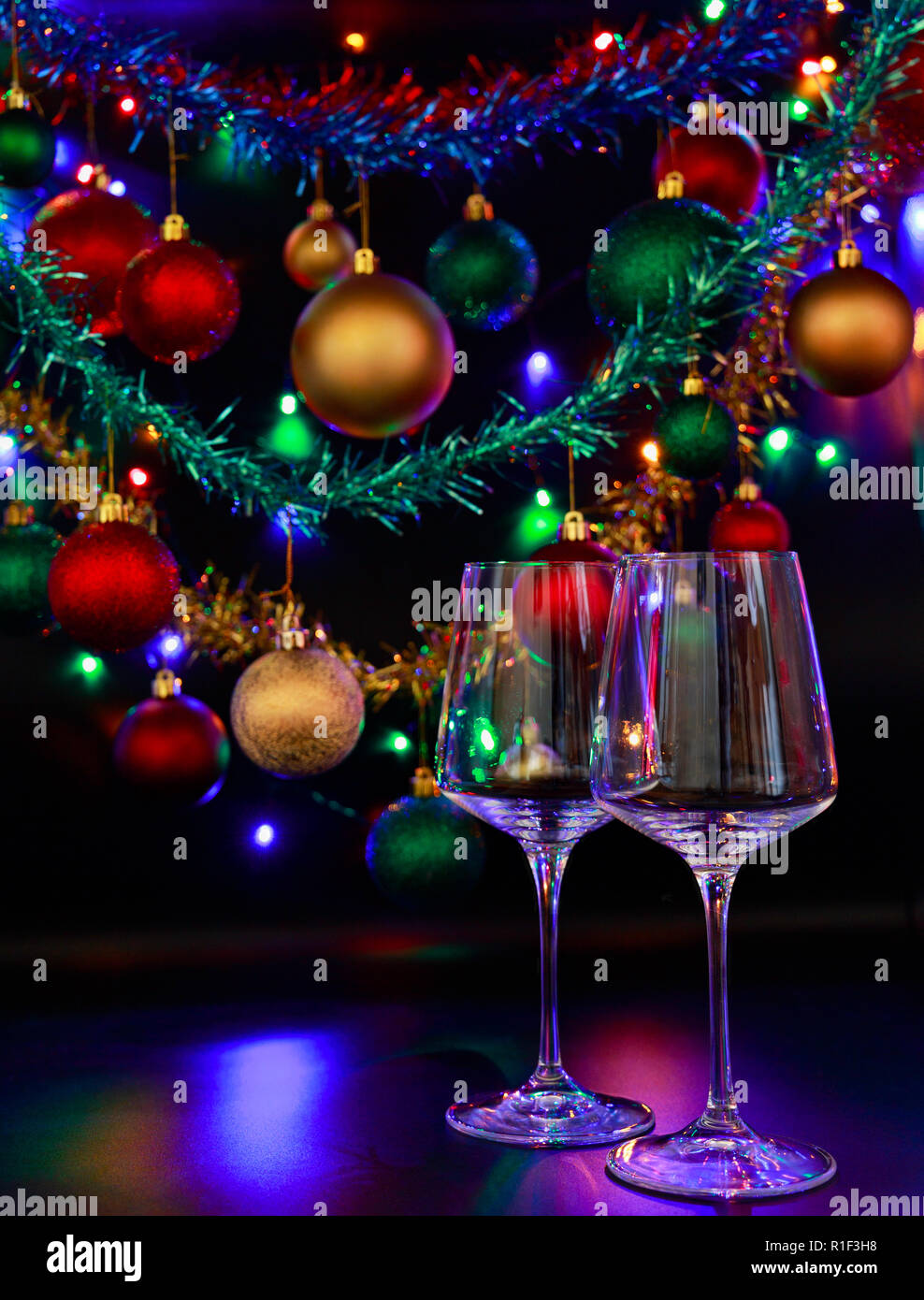 Los dos vasos de vino con un trasfondo de coloridos adornos navideños y  luces de Navidad Fotografía de stock - Alamy