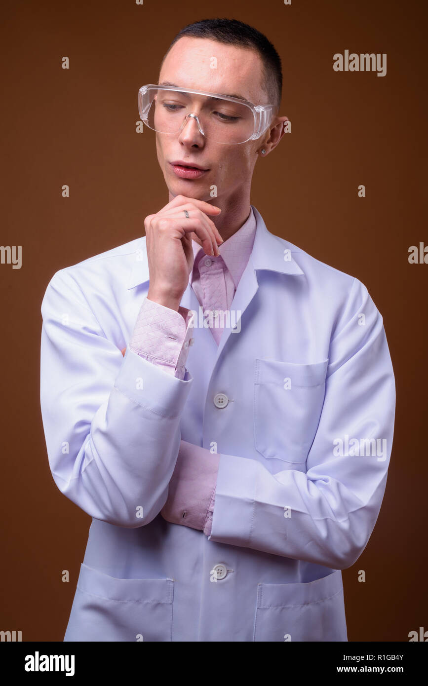 Joven apuesto hombre andrógino doctor llevar gafas de protección Foto de stock